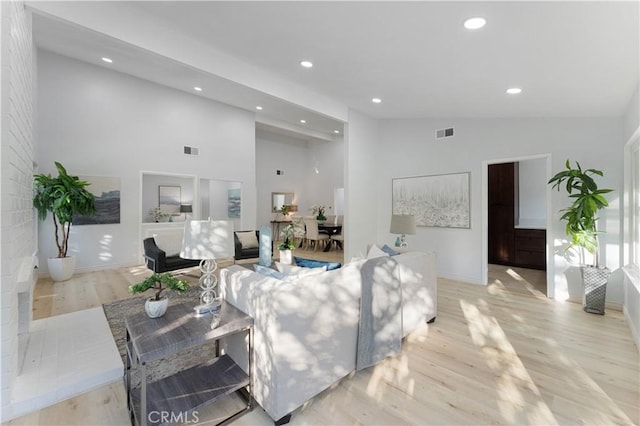 living room featuring vaulted ceiling and light hardwood / wood-style floors