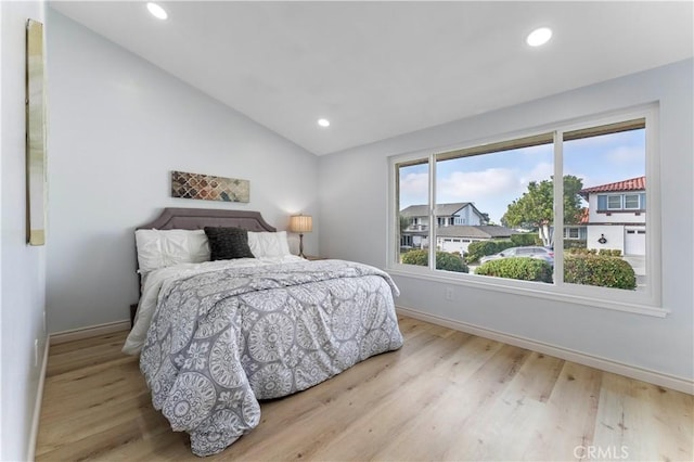 bedroom with vaulted ceiling and light hardwood / wood-style floors