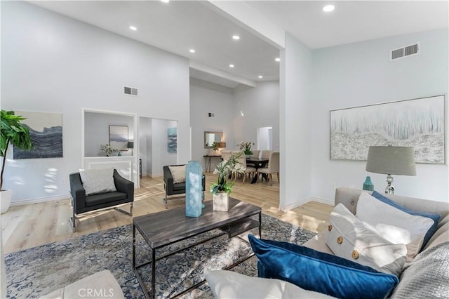 living room featuring light hardwood / wood-style floors and high vaulted ceiling