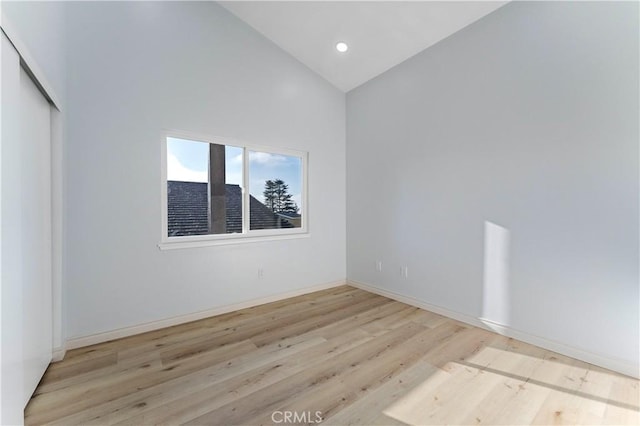 unfurnished room featuring high vaulted ceiling and light hardwood / wood-style floors