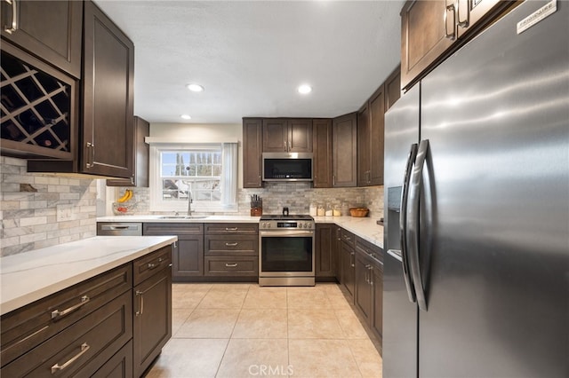 kitchen with sink, stainless steel appliances, tasteful backsplash, and dark brown cabinetry