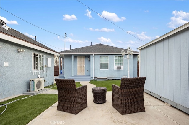 rear view of house with a lawn, ac unit, cooling unit, and a patio