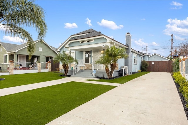 bungalow-style home with a front yard and covered porch