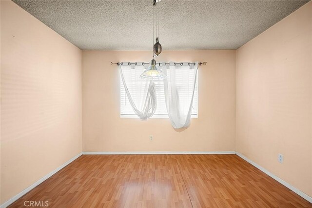 spare room featuring a textured ceiling and hardwood / wood-style floors