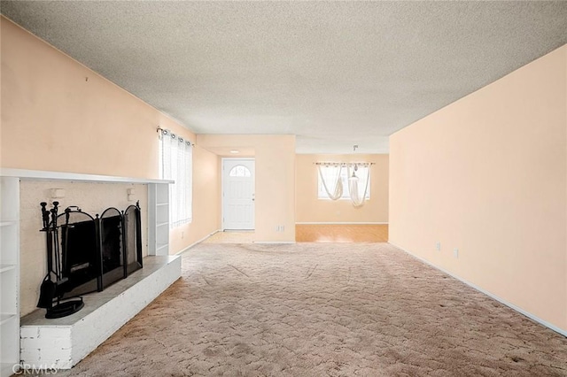 unfurnished living room with carpet flooring and a textured ceiling