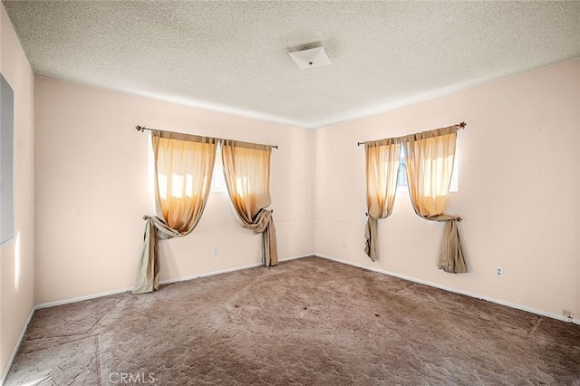 carpeted spare room featuring a textured ceiling