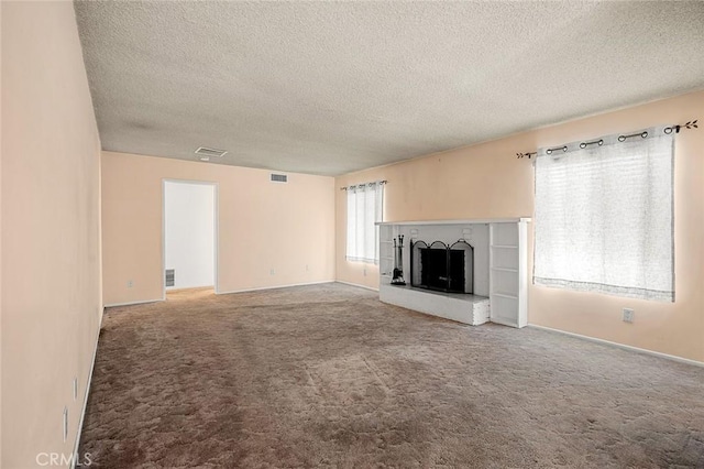 unfurnished living room with a textured ceiling and carpet flooring