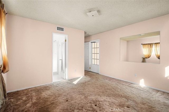 spare room with a textured ceiling and carpet