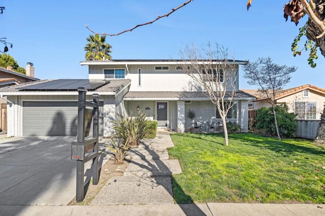 front of property with solar panels, a front lawn, and a garage