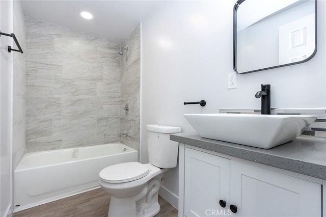 full bathroom with toilet, vanity, hardwood / wood-style floors, and tiled shower / bath