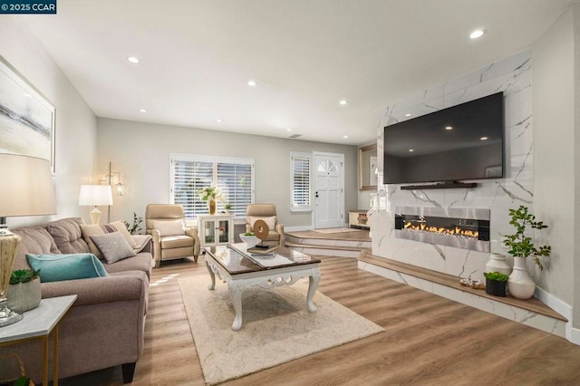 living room with light hardwood / wood-style flooring and a high end fireplace