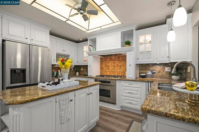 kitchen with appliances with stainless steel finishes, a kitchen island, and white cabinets