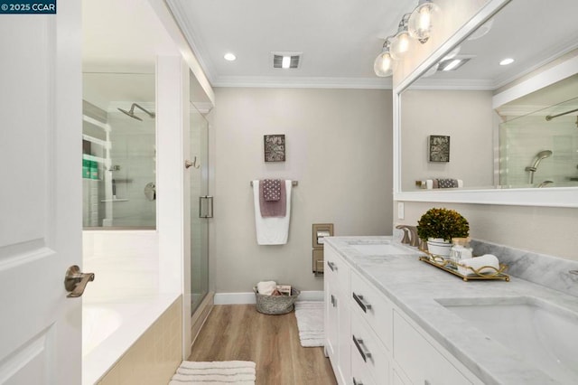 bathroom featuring hardwood / wood-style flooring, ornamental molding, separate shower and tub, and vanity