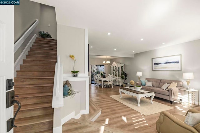 living room featuring wood-type flooring and an inviting chandelier