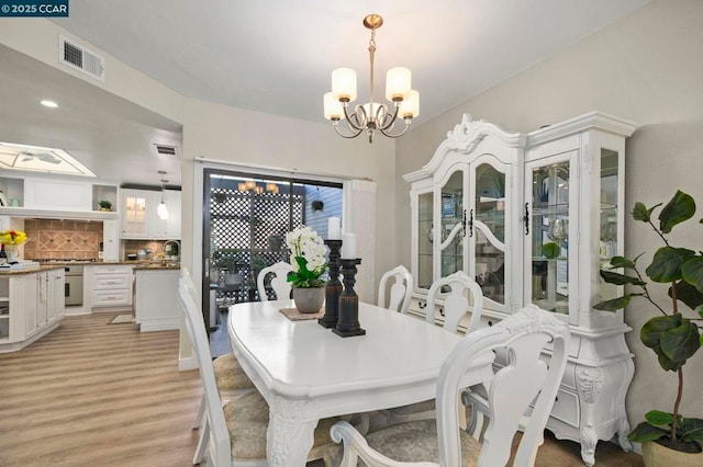 dining room with an inviting chandelier and light hardwood / wood-style flooring