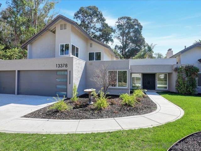 contemporary house with a front yard and a garage