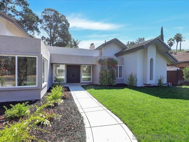 single story home featuring a front lawn