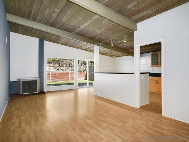 unfurnished living room with a large fireplace, light wood-type flooring, wood ceiling, and vaulted ceiling with beams