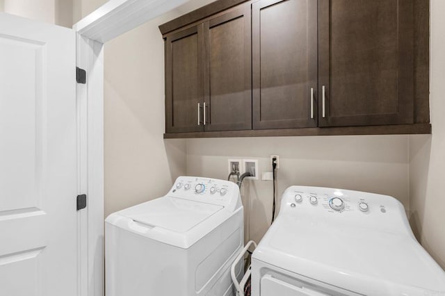 clothes washing area with cabinet space and independent washer and dryer