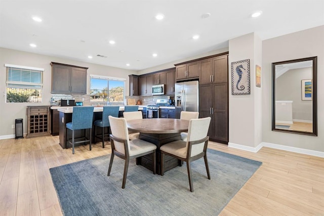 dining area featuring light wood-type flooring, baseboards, and recessed lighting