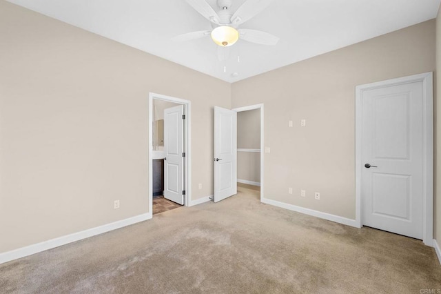 unfurnished bedroom featuring ceiling fan, carpet flooring, connected bathroom, and baseboards