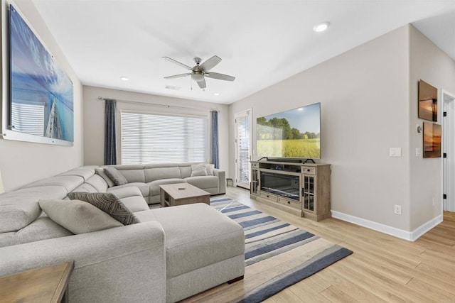 living area with a fireplace, light wood finished floors, recessed lighting, a ceiling fan, and baseboards