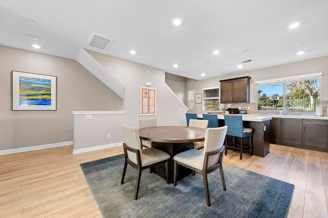 dining space featuring light wood-style flooring, recessed lighting, visible vents, and baseboards