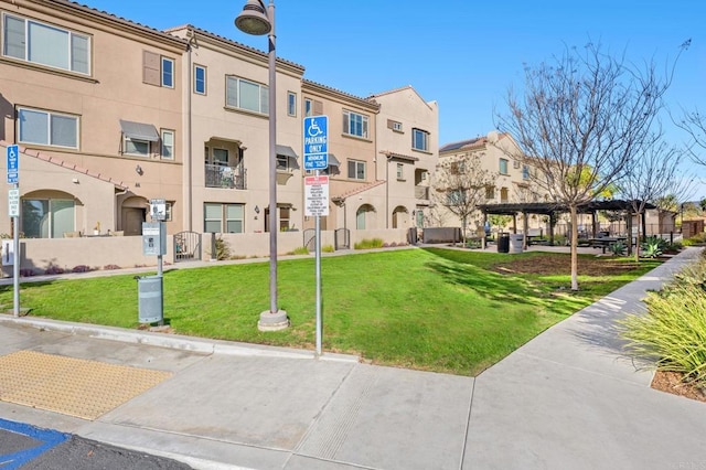 surrounding community featuring a yard and a pergola