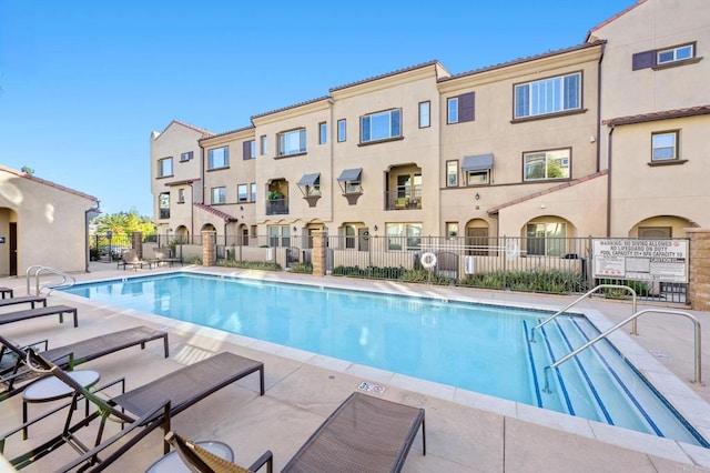 community pool featuring a patio area and fence