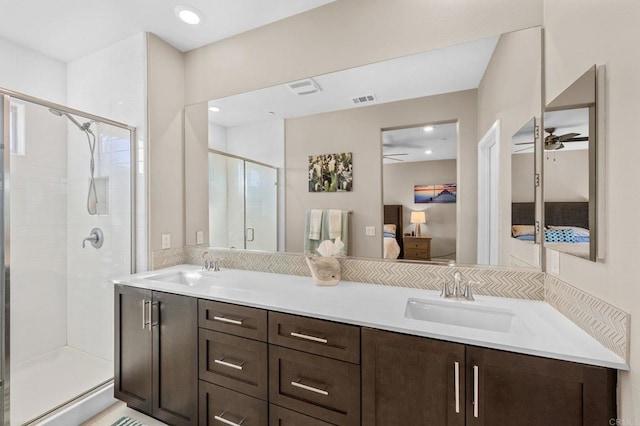 ensuite bathroom with visible vents, a ceiling fan, a sink, a shower stall, and ensuite bath