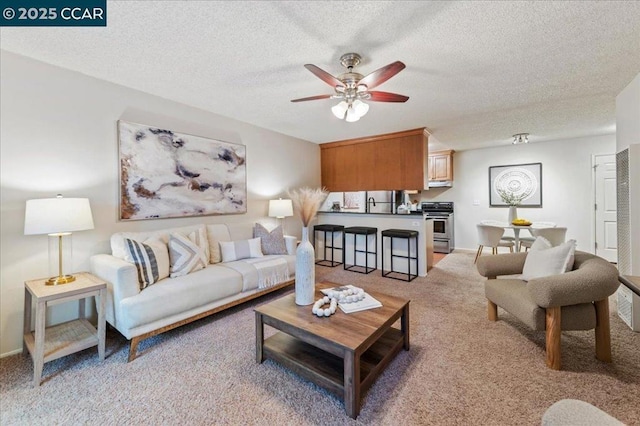 carpeted living room with a textured ceiling and ceiling fan