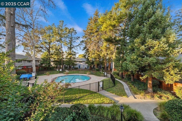 view of pool featuring a lawn