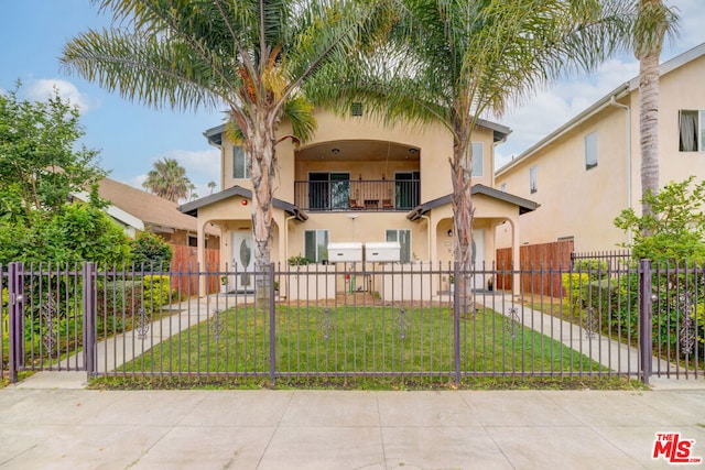 mediterranean / spanish-style house featuring a front yard and a balcony