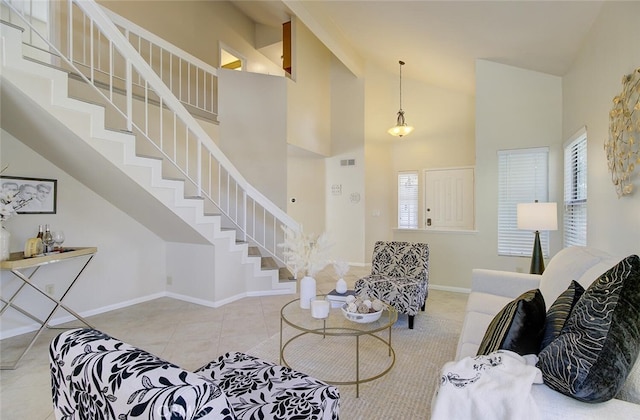 living room featuring a high ceiling, a wealth of natural light, and light tile patterned flooring