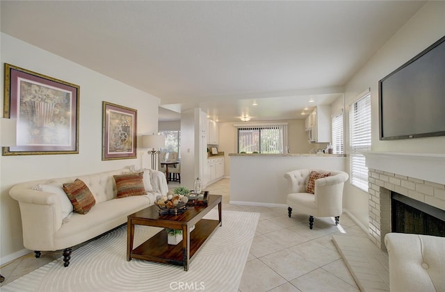 living room with a brick fireplace and light tile patterned floors