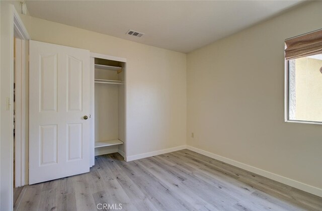 unfurnished bedroom featuring light wood-type flooring and a closet