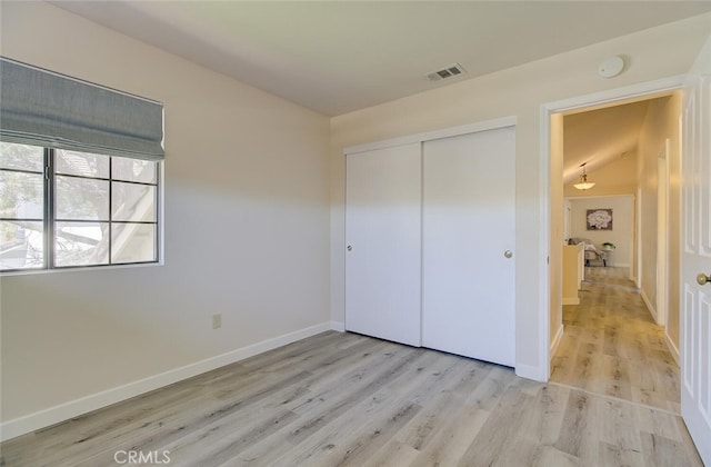 unfurnished bedroom with a closet and light wood-type flooring