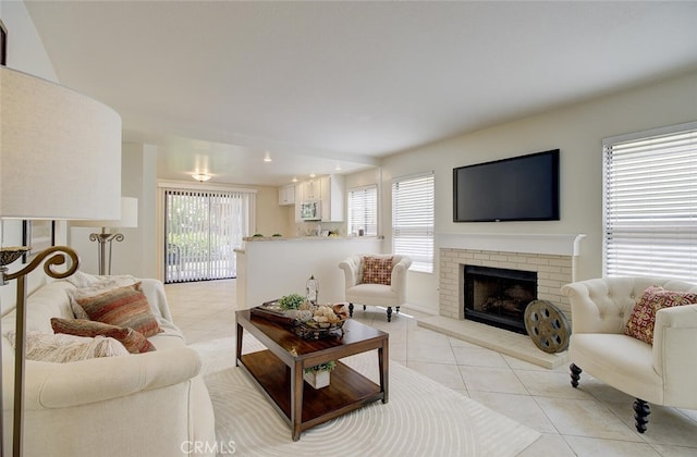 living room featuring a brick fireplace and light tile patterned flooring