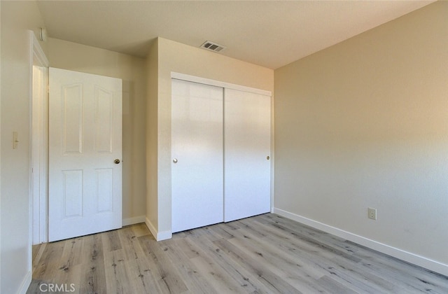 unfurnished bedroom with a closet and light hardwood / wood-style floors