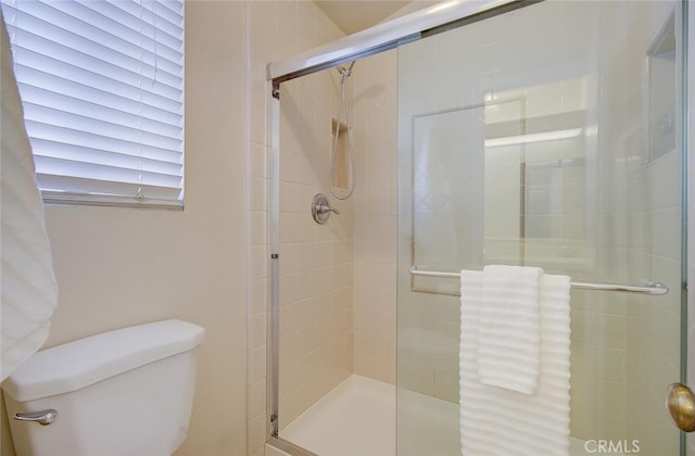 bathroom featuring toilet and an enclosed shower