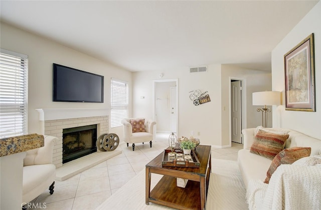 tiled living room with a brick fireplace and plenty of natural light