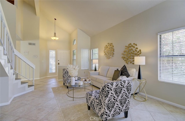 living room featuring high vaulted ceiling, light tile patterned floors, and a wealth of natural light