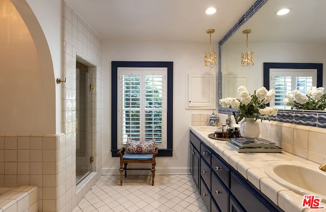 bathroom featuring vanity, a shower with shower door, and tile patterned floors