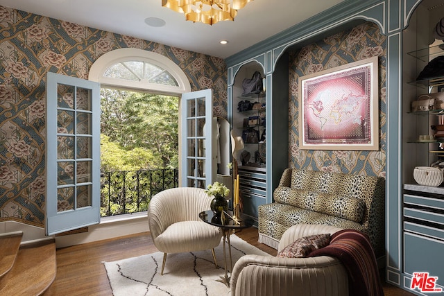 sitting room featuring hardwood / wood-style floors and a chandelier