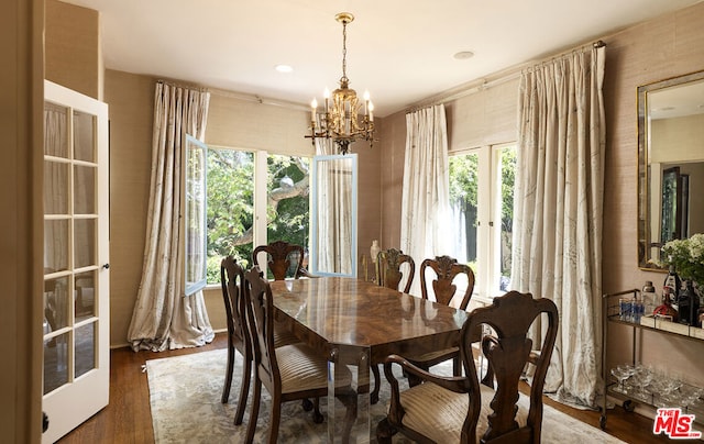 dining space featuring dark hardwood / wood-style floors, an inviting chandelier, and french doors