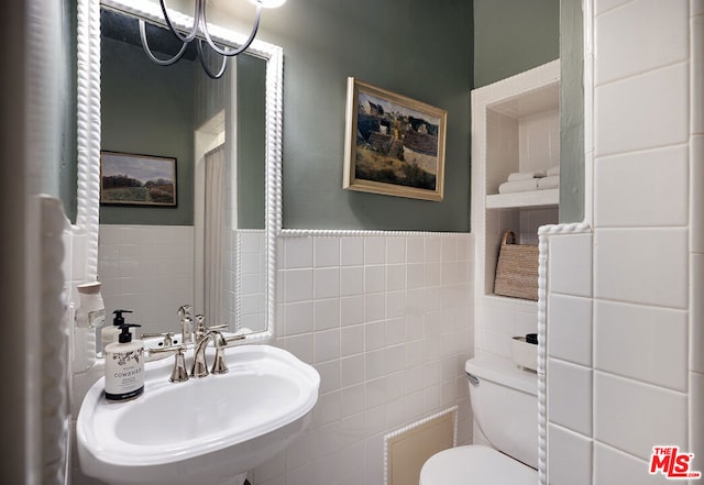 bathroom with tile walls, sink, and toilet