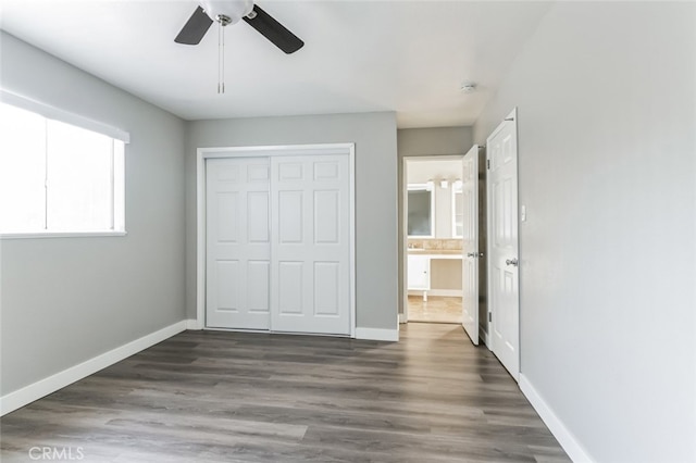 unfurnished bedroom featuring ceiling fan, a closet, and dark hardwood / wood-style floors