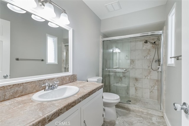 bathroom with toilet, vanity, tile patterned flooring, and a shower with shower door