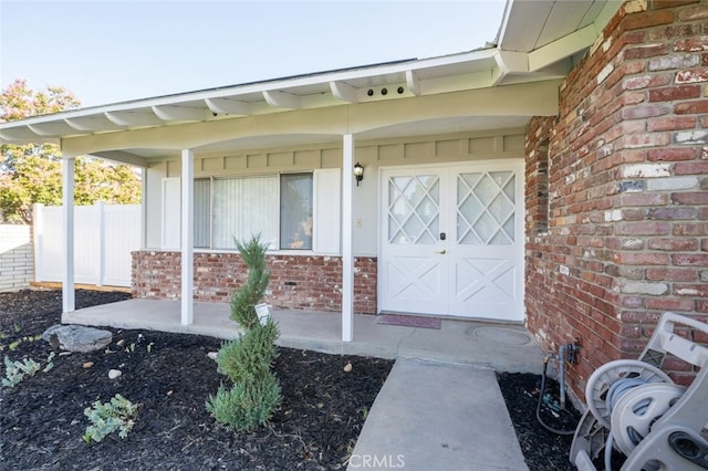 view of exterior entry with a garage and a porch