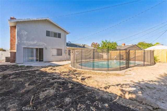 rear view of house featuring a patio area and a fenced in pool